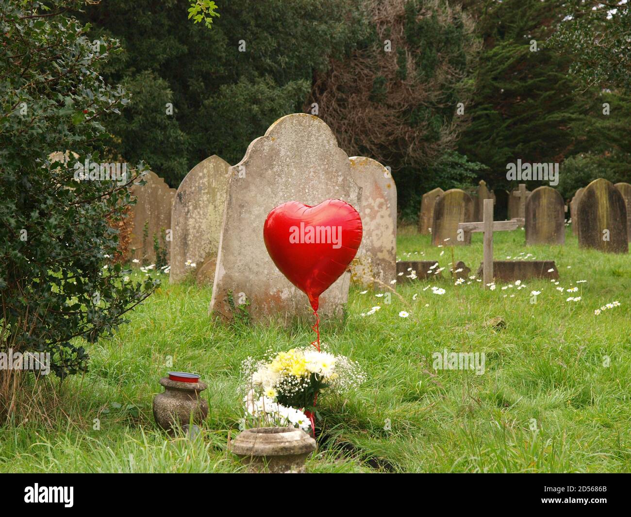 Globo en forma de corazón rojo en un cementerio Foto de stock