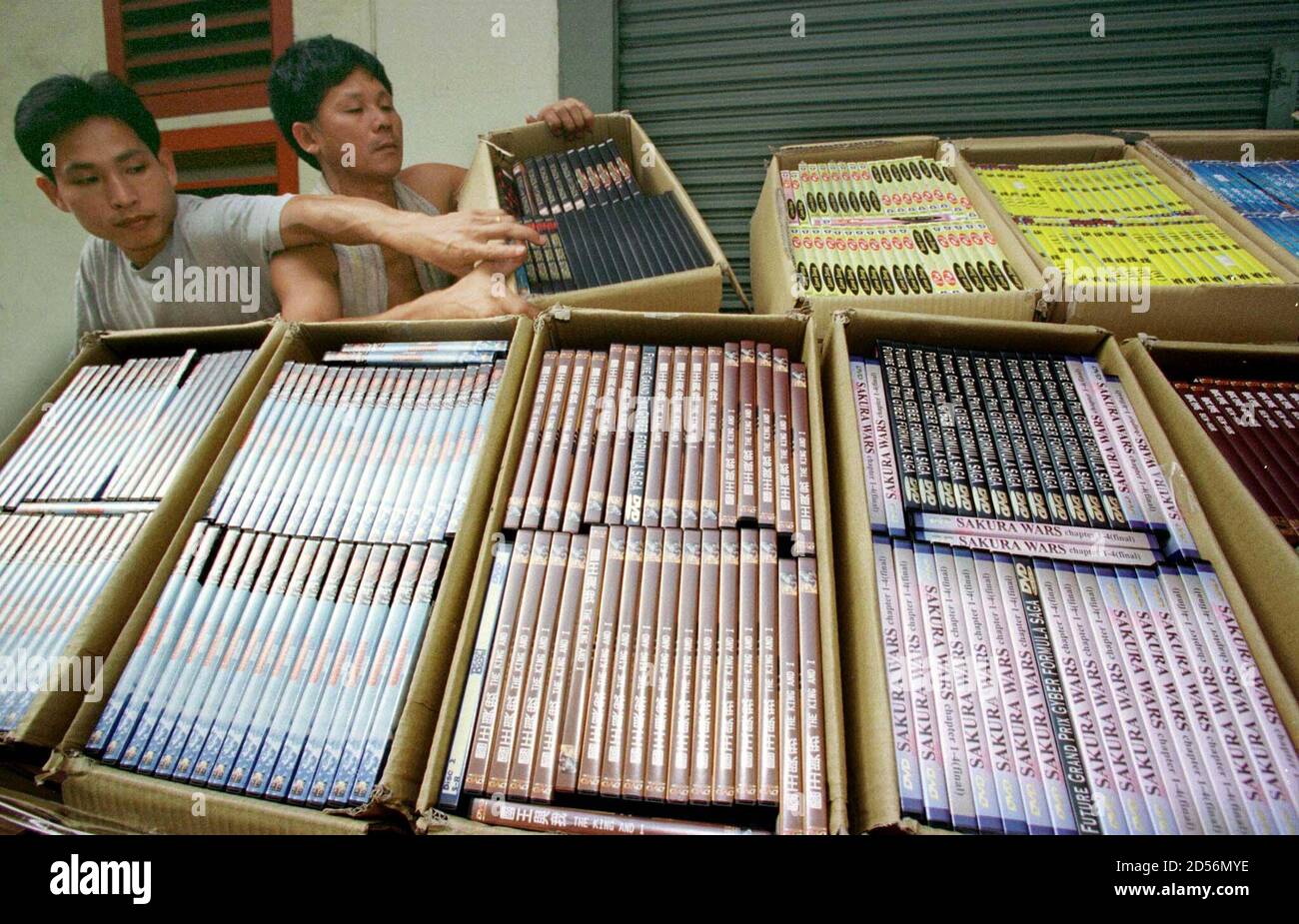 Los trabajadores exhiben discos de Video Digital (DVD) pirateados en una  conferencia de prensa en Hong Kong el 6 de noviembre. Los funcionarios de  aduanas de Hong Kong confiscaron más de 270,000
