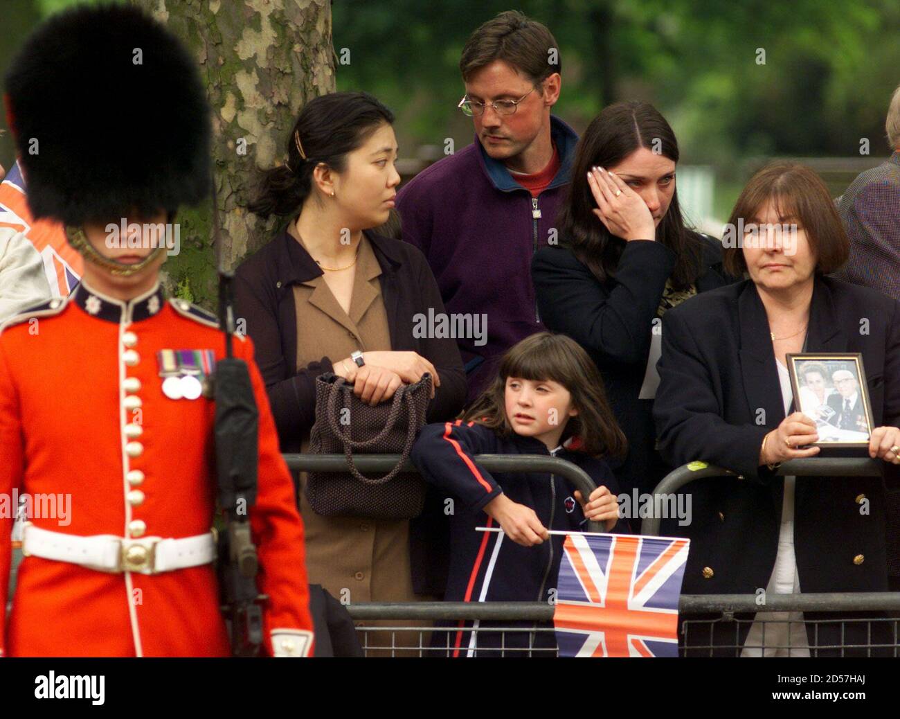 Una mujer llora (2R) mientras el emperador japonés Akihito y la procesión  de la Reina, pasa por el centro comercial hasta el Palacio de Buckingham el  26 de mayo. La visita del