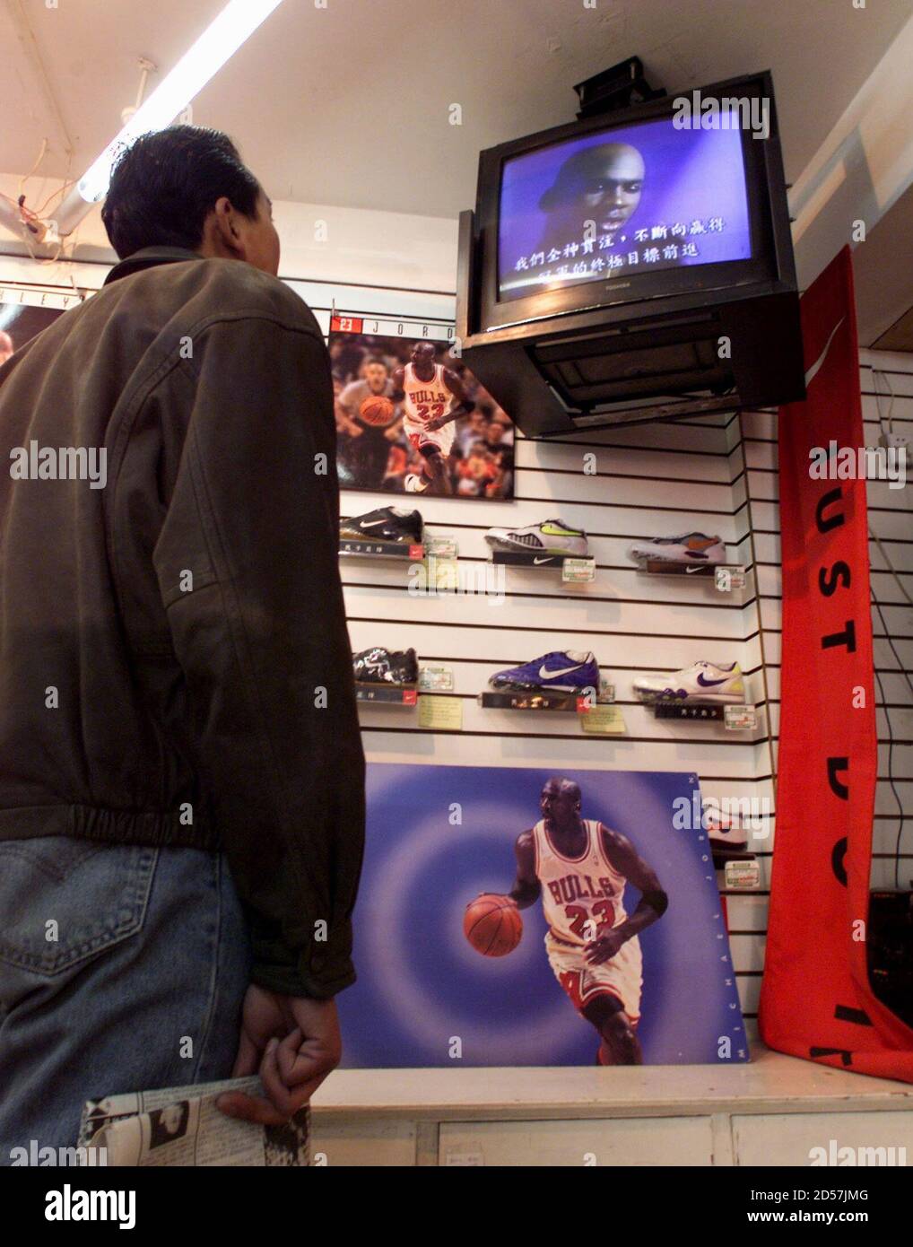 Un cliente chino, de pie frente a los carteles de Michael Jordan, ve un  documento de televisión de la estrella de la Asociación Nacional de  Baloncesto (NBA) en una tienda de deportes