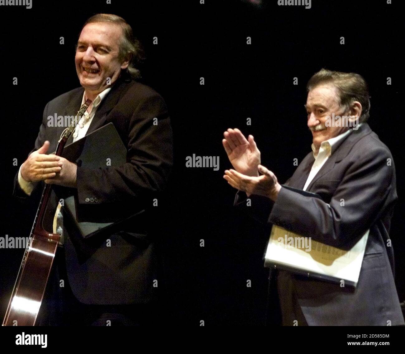 El escritor uruguayo Mario Benedetti (R) y el músico Daniel Viglietti  aplaudieron a una multitud animadora al final de su actuación en un teatro  de Madrid el 22 de mayo. Benedetti recitó