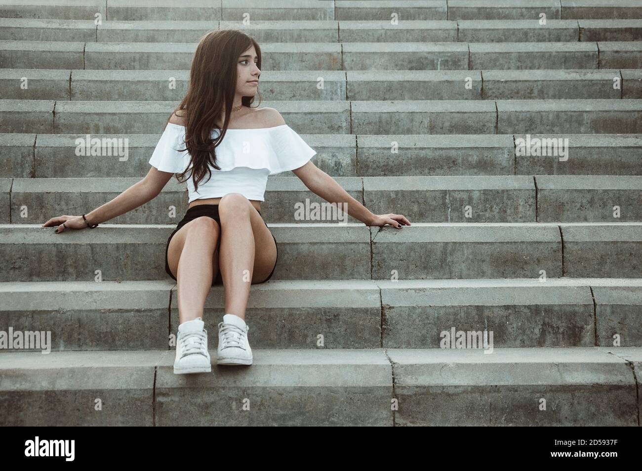 Niña adolescente sentada en los escalones, España Foto de stock