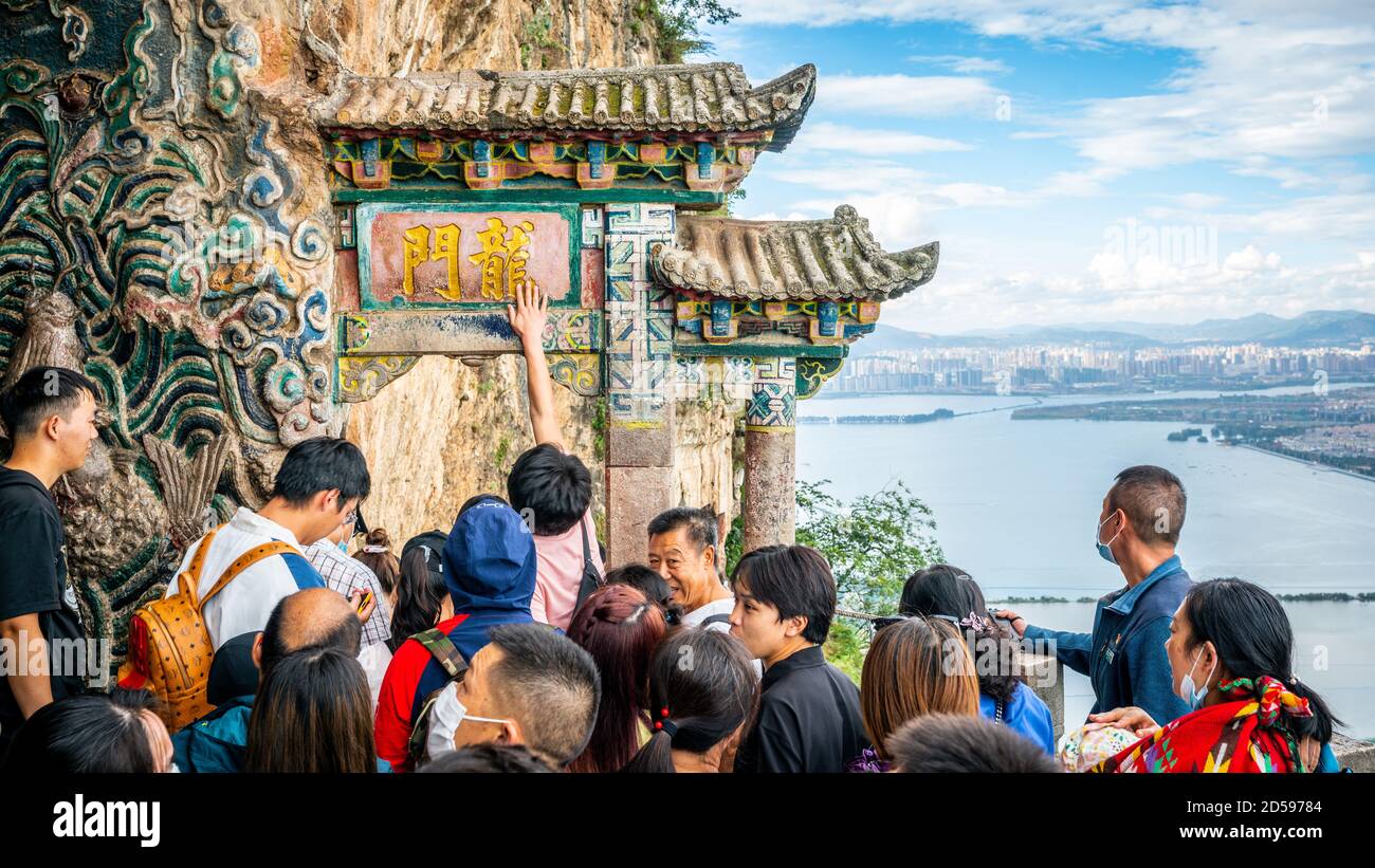 Kunming China , 3 de octubre de 2020 : turistas chinos que intentan tocar la puerta del dragón de West Hill o Longmen por buena suerte en Kunming Yunnan China Foto de stock