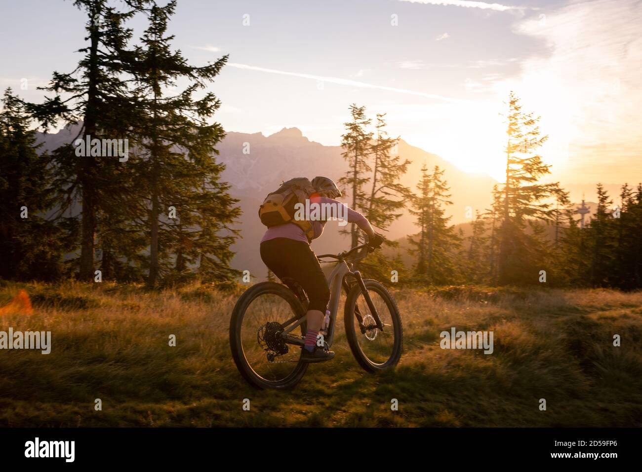 Mujer ciclismo de montaña en las montañas al amanecer, Fadstadt, Salzburgo, Austria Foto de stock