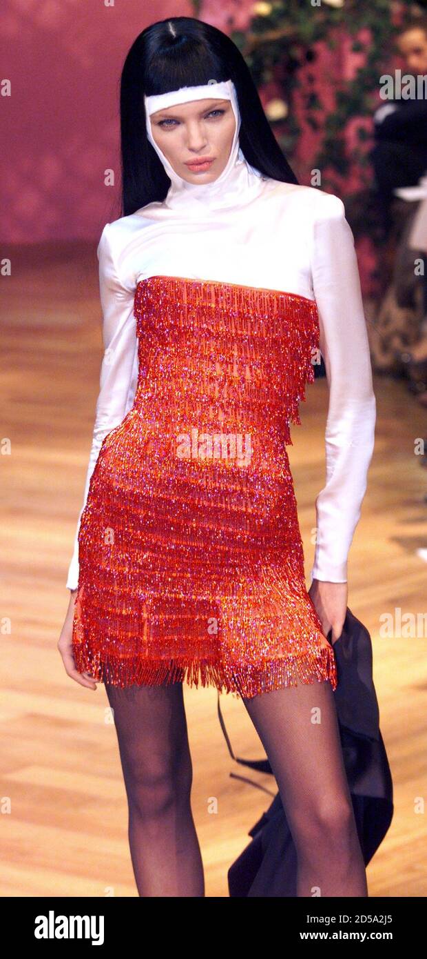 Un modelo para la casa de moda francesa Givenchy con un traje diseñado por  el diseñador británico Alexander McQueen presenta este vestido de cóctel  con flecos rojos sobre una parte superior con
