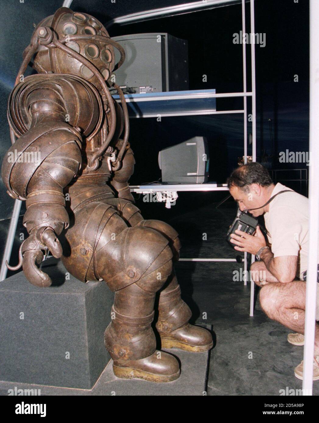 A visitor uses a video camera to film the world's oldest diving suit