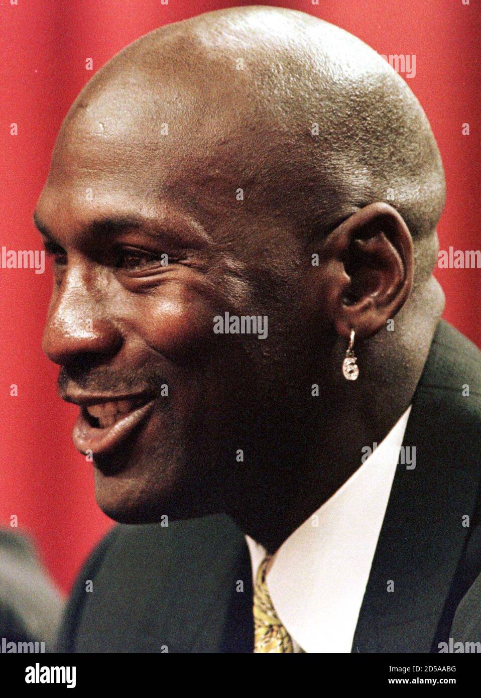 Chicago Bulls' Michael Jordan, wearing a number six earring in reference to  the six world championships the Bulls won, smiles at a news conference at  which he announced his retirement from basketball