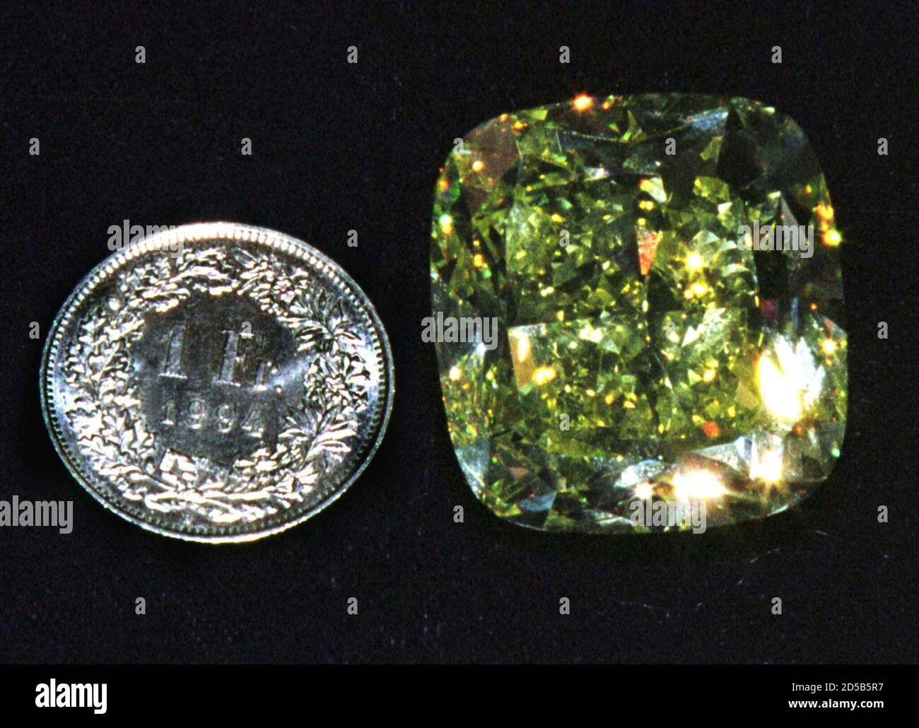 El 'Mouna', el diamante amarillo más grande del mundo, se muestra junto a  un franco suizo en Ginebra el 16 de noviembre. El valor del diamante  amarillo en forma de cojín se