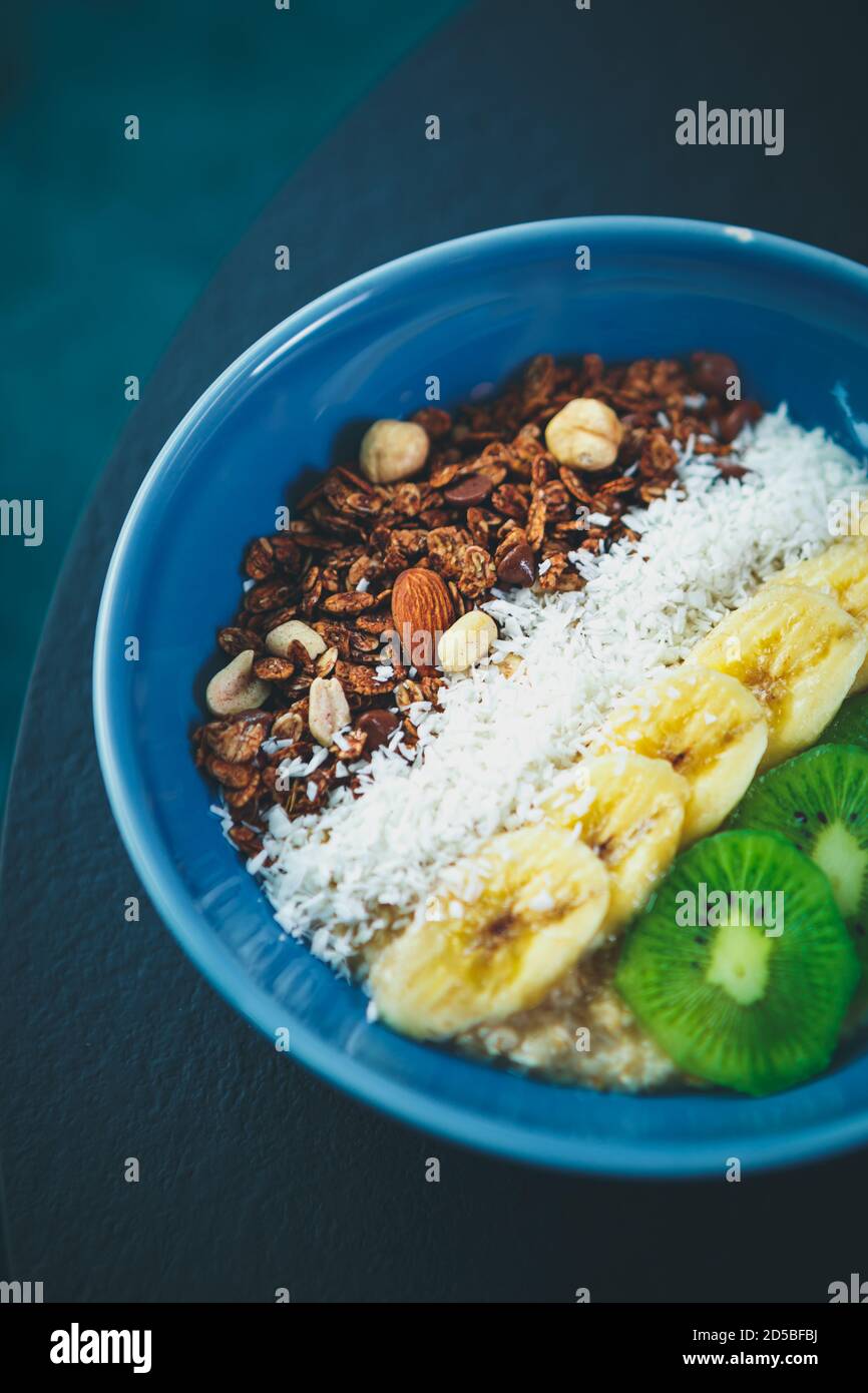 Deliciosa comida vegetariana en un plato de cerámica azul Mesa en vegan cafe.ingredientes frescos de comida natural preparados para el desayuno.hervidos blanco Foto de stock