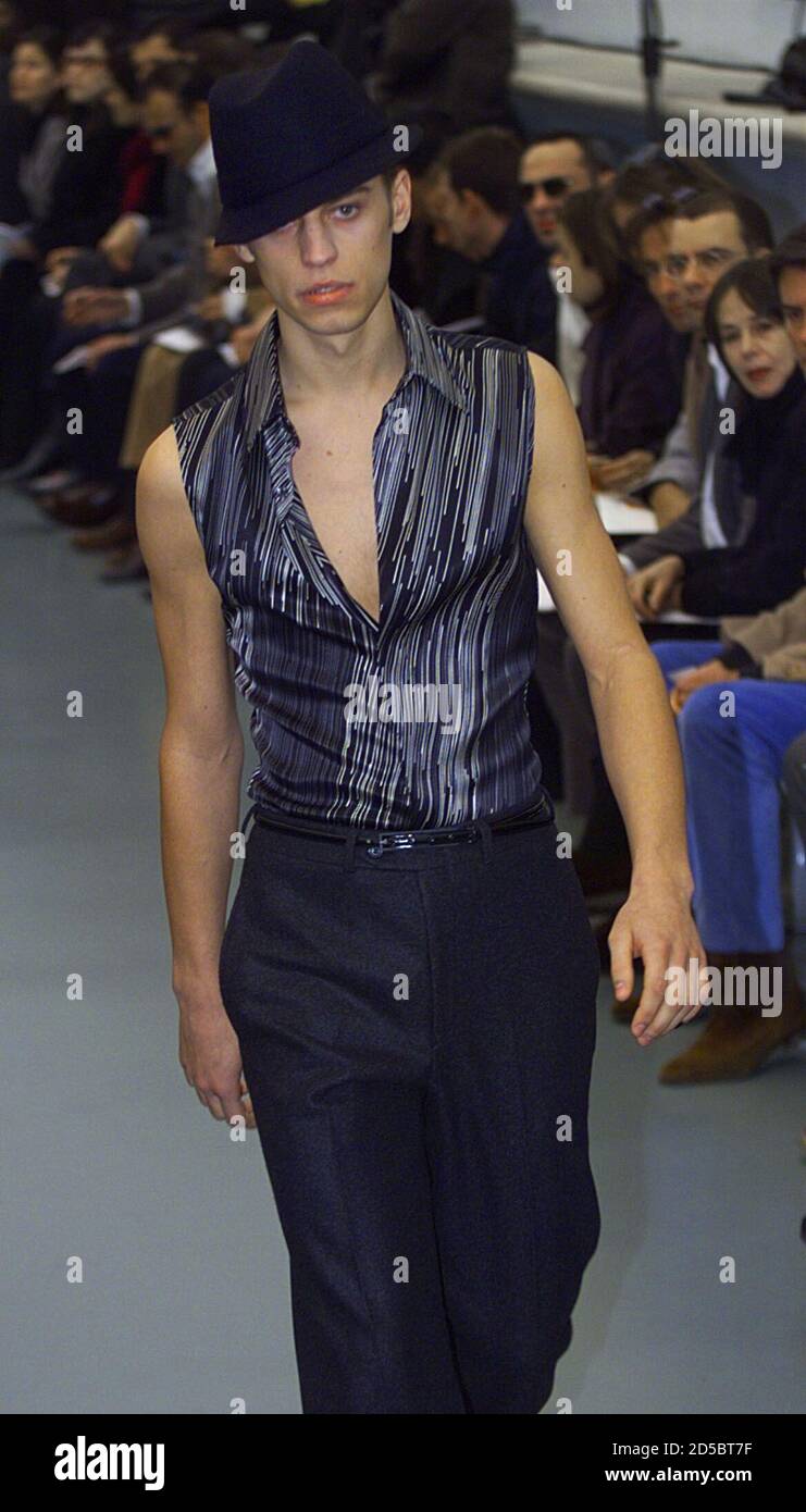 Un modelo para la casa de moda francesa Yves Saint Laurent presenta esta  camisa sin mangas de rayas grises y blancas sobre pantalones grises azules  y sombrero trilby como parte de su