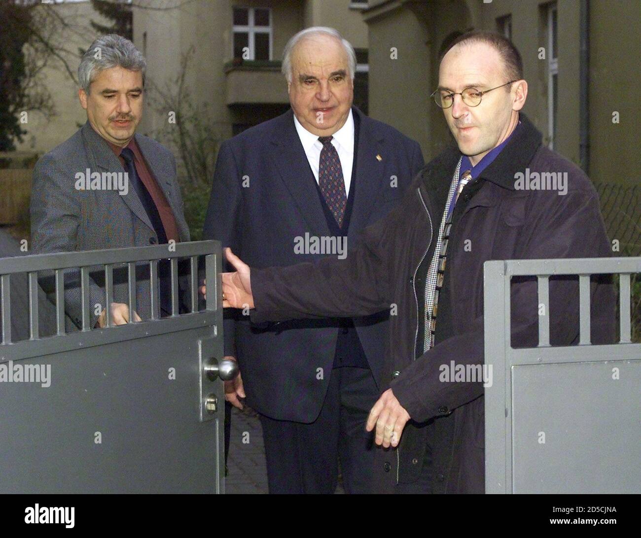 Helmut Kohl (C), former German Chancellor and Christian Democratic (CDU)  chairman leaves his home in Berlin's Grunewald district, flanked by his  body guards January 20 as the German lower house the Bundestag