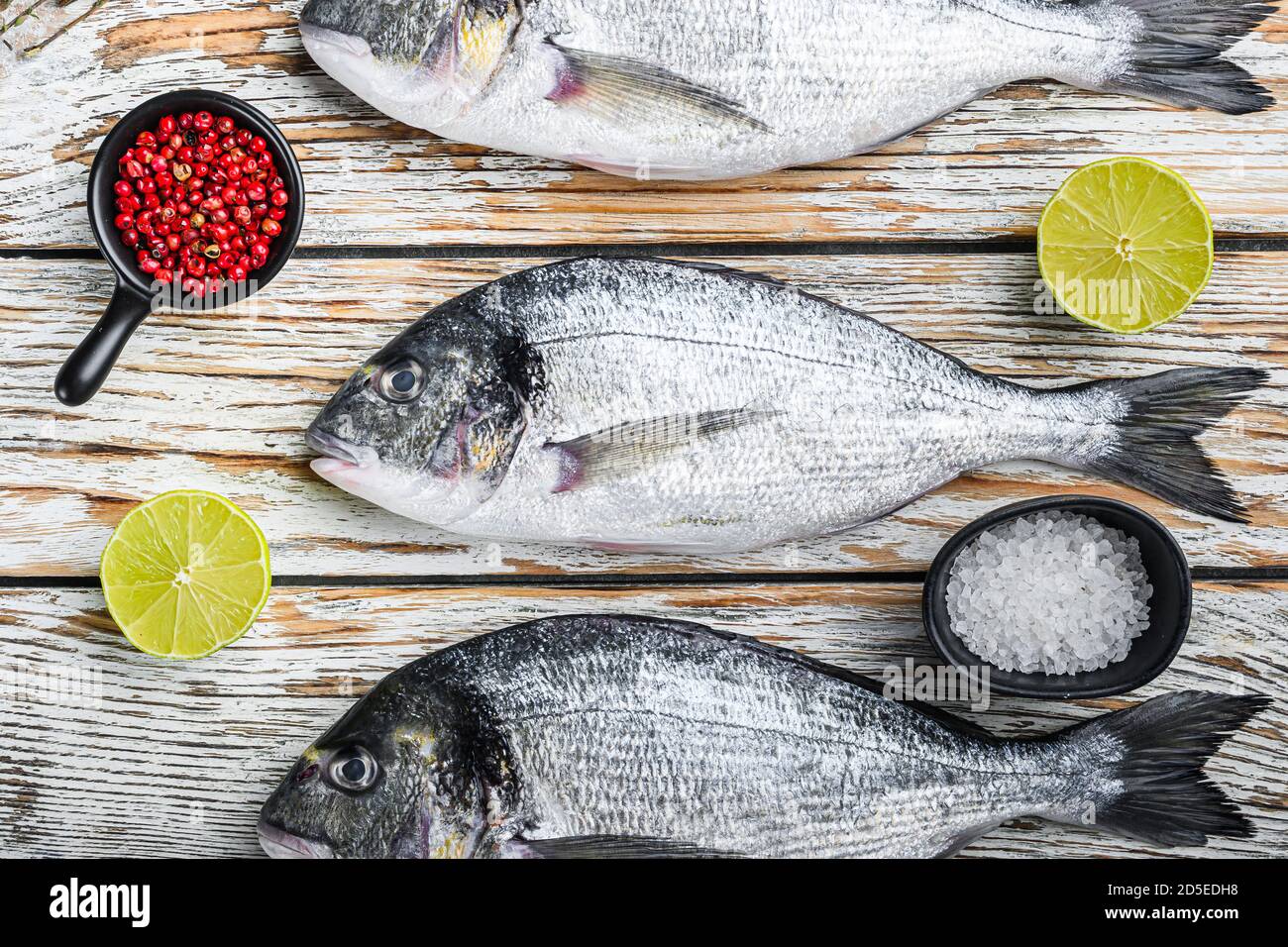 Entero dorado pescado de besugo con hierbas para asar a la parrilla vista  superior de la mesa de madera blanca Fotografía de stock - Alamy