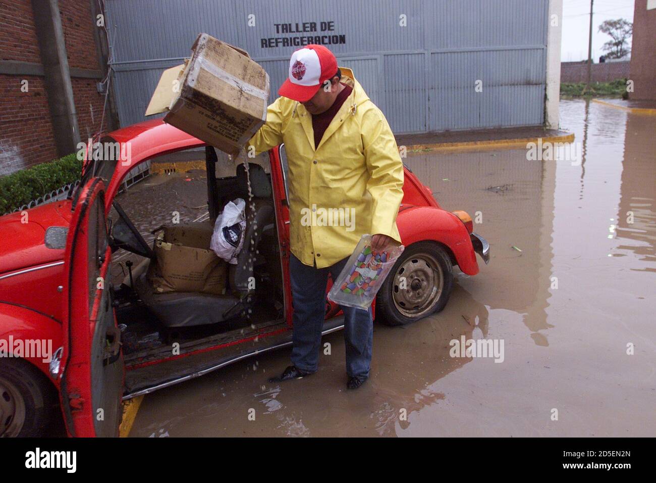 Raúl García vacía el agua de una caja de cartón dejada en su coche de  empresa antes de que fuera sumergida por las aguas de inundación ayer en el  distribuidor local de