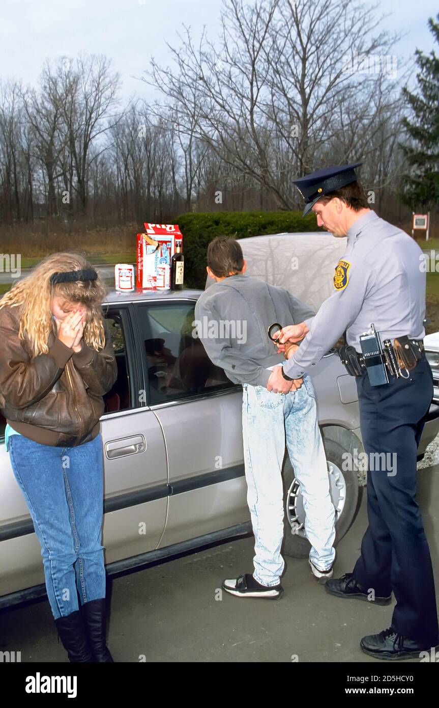 DUI o arresto de conducir ebrio por un oficial de policía con alcohol abuso entre hombres y mujeres jóvenes Foto de stock