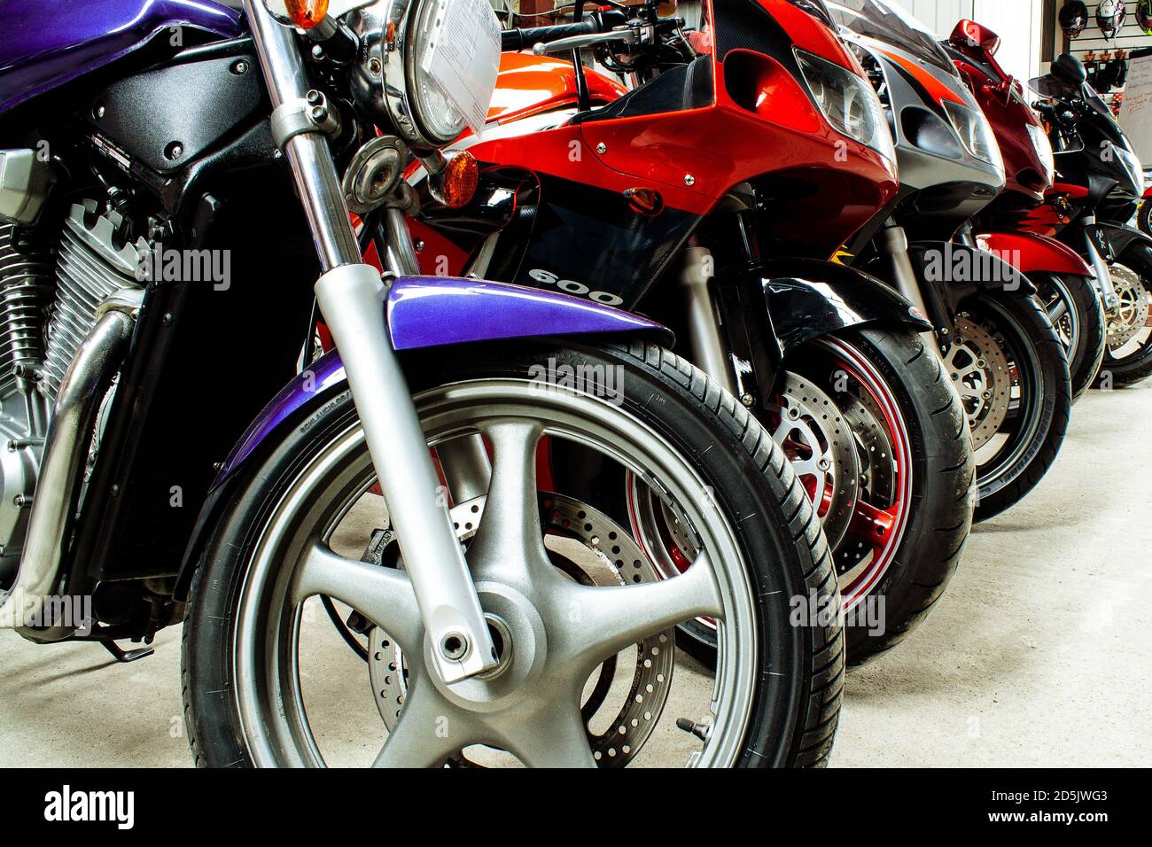 Hermoso estacionamiento de grupo de motocicletas sala de exposición para la venta, en un primer plano de la tienda. Mantenimiento de motos deportivas, bicicletas de carretera en el taller. Piezas