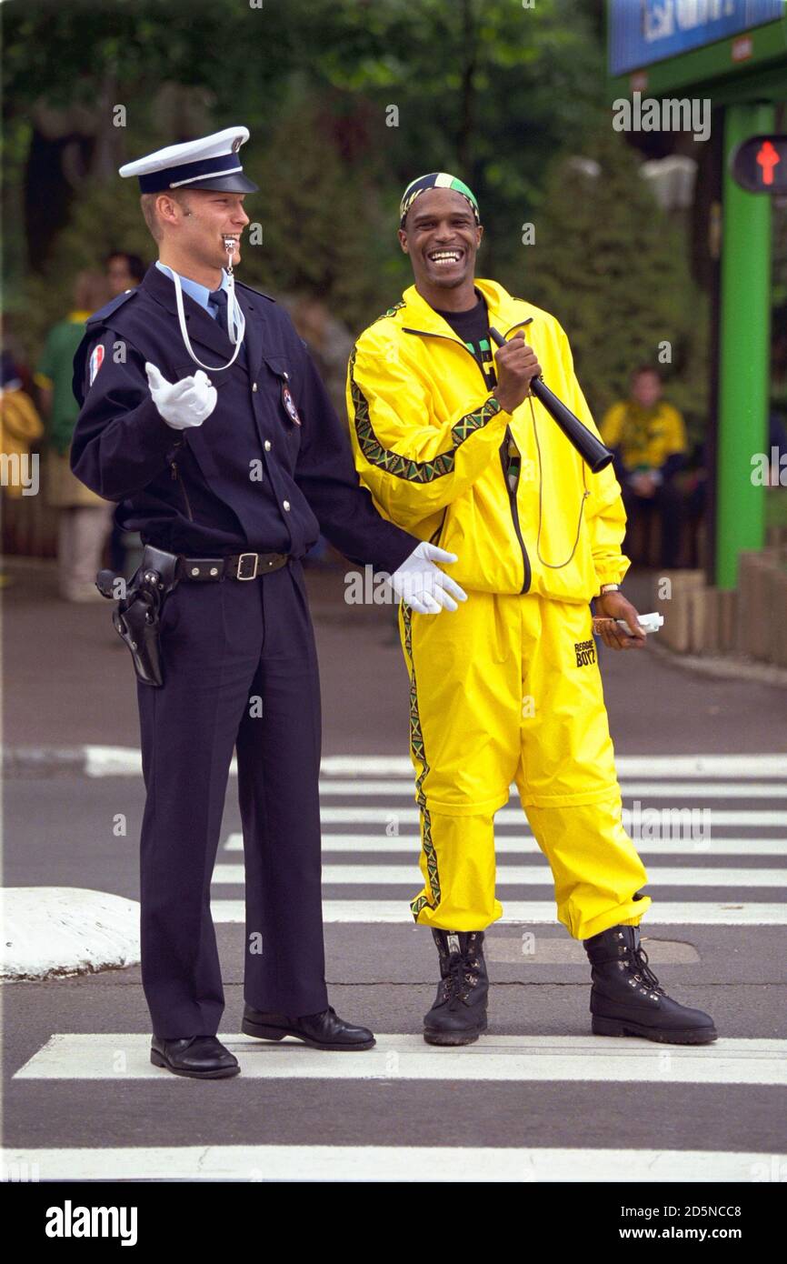 Un fan de Jamaica en un traje de concha tiene una risa con un policía local  Fotografía de stock - Alamy