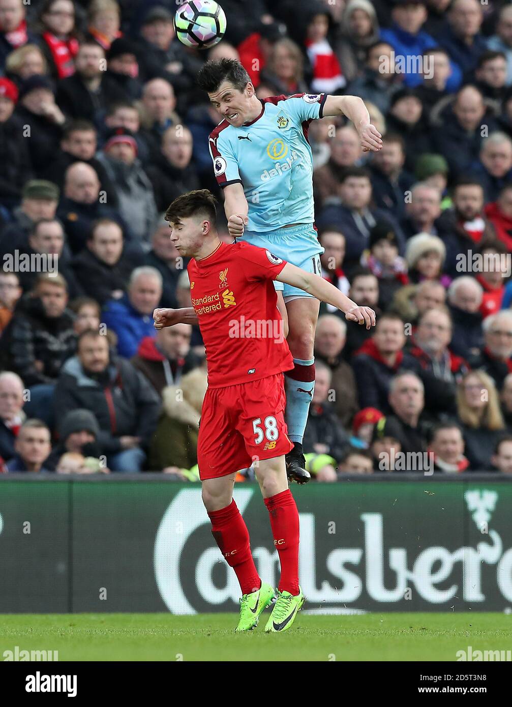 Oviemuno Ejaria de Liverpool (izquierda) y Joey Barton (derecha) de Burnley para la bola en el aire Foto de stock