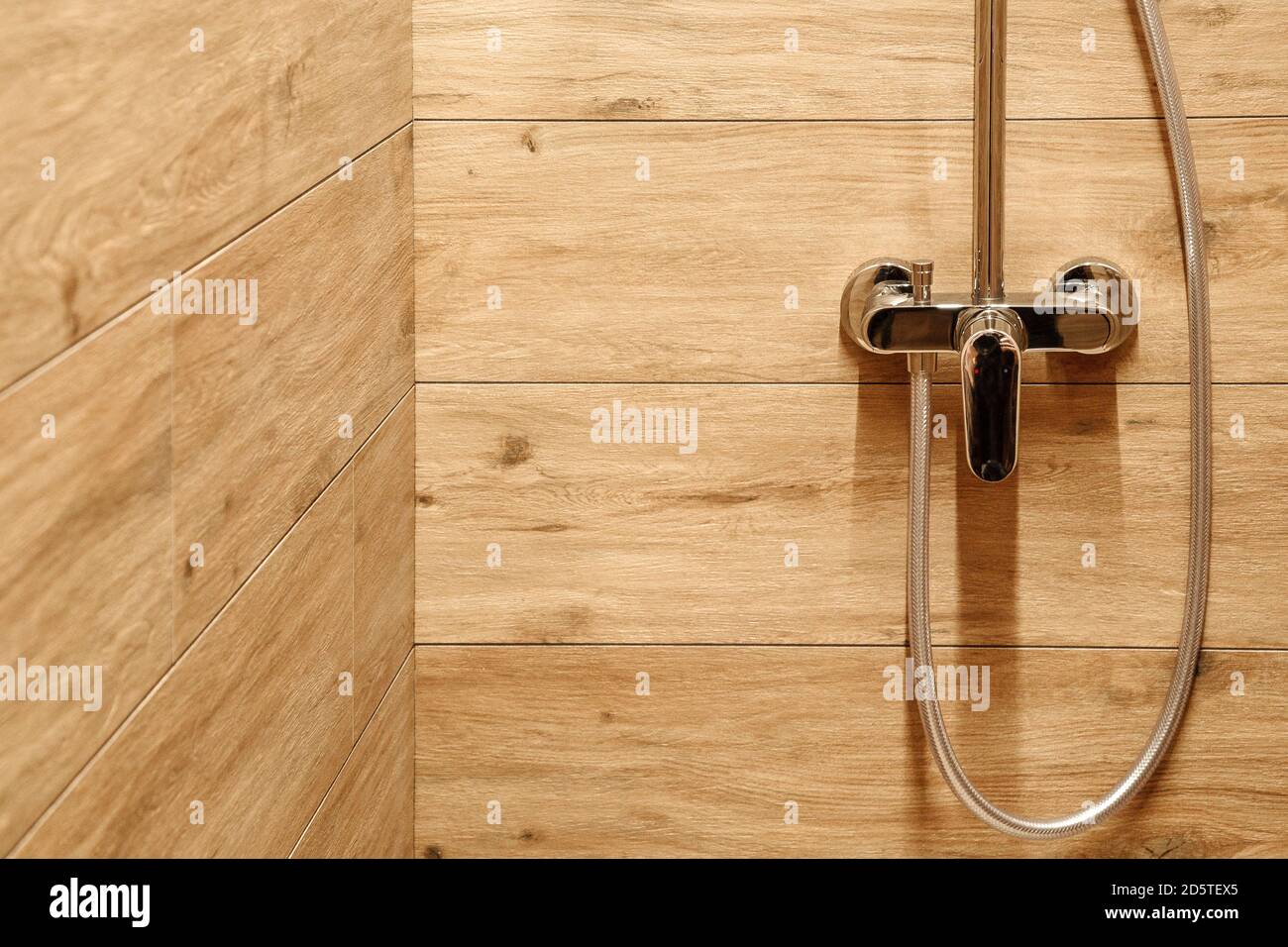 agua mezcladora de acero en la ducha con azulejos de madera Fotografía de  stock - Alamy