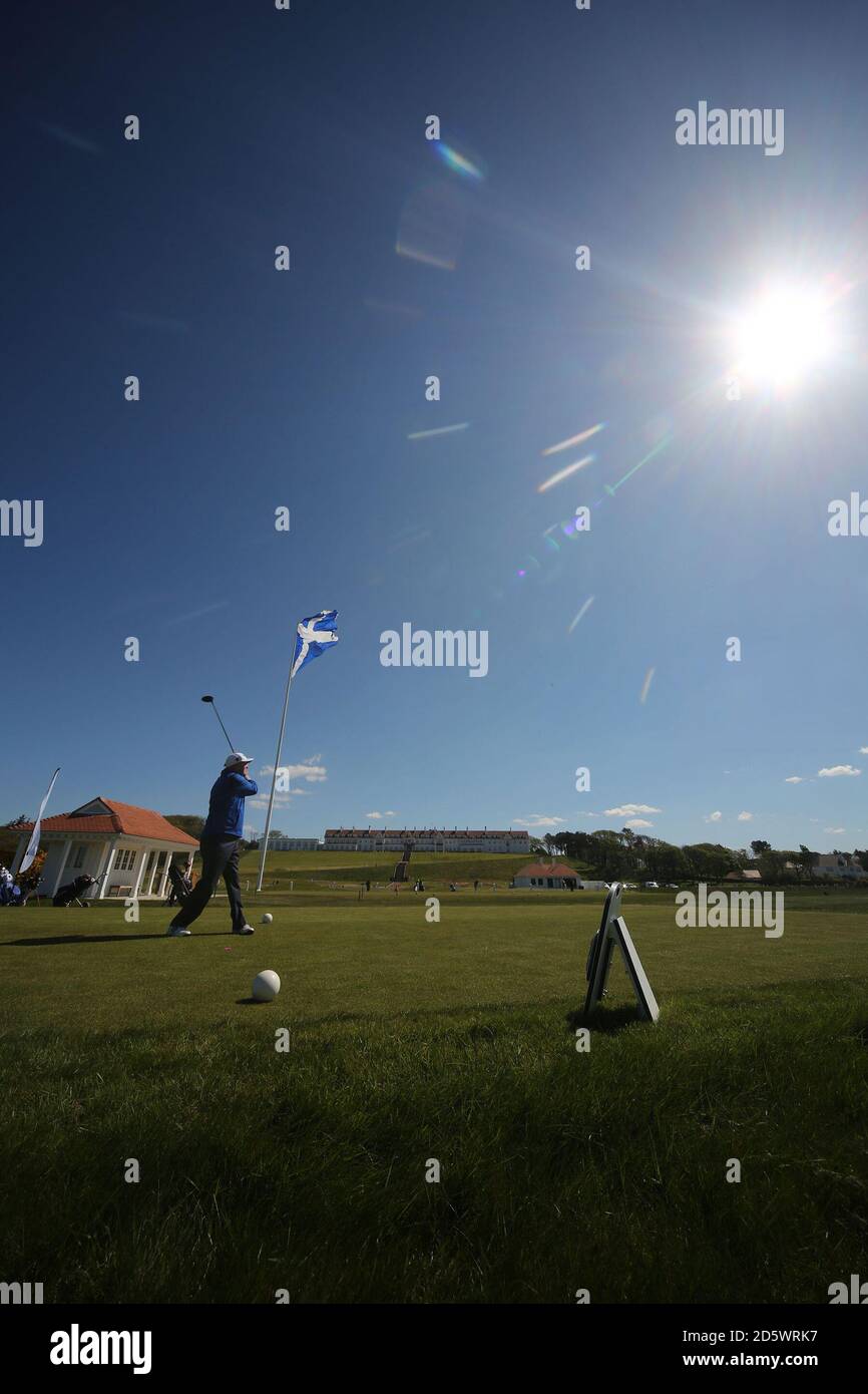 Trump Turnberry Golf Course First tee and starters Hut con Turnberry Hotel y la gran bandera de Satlire, golfista se aparta del tee Foto de stock