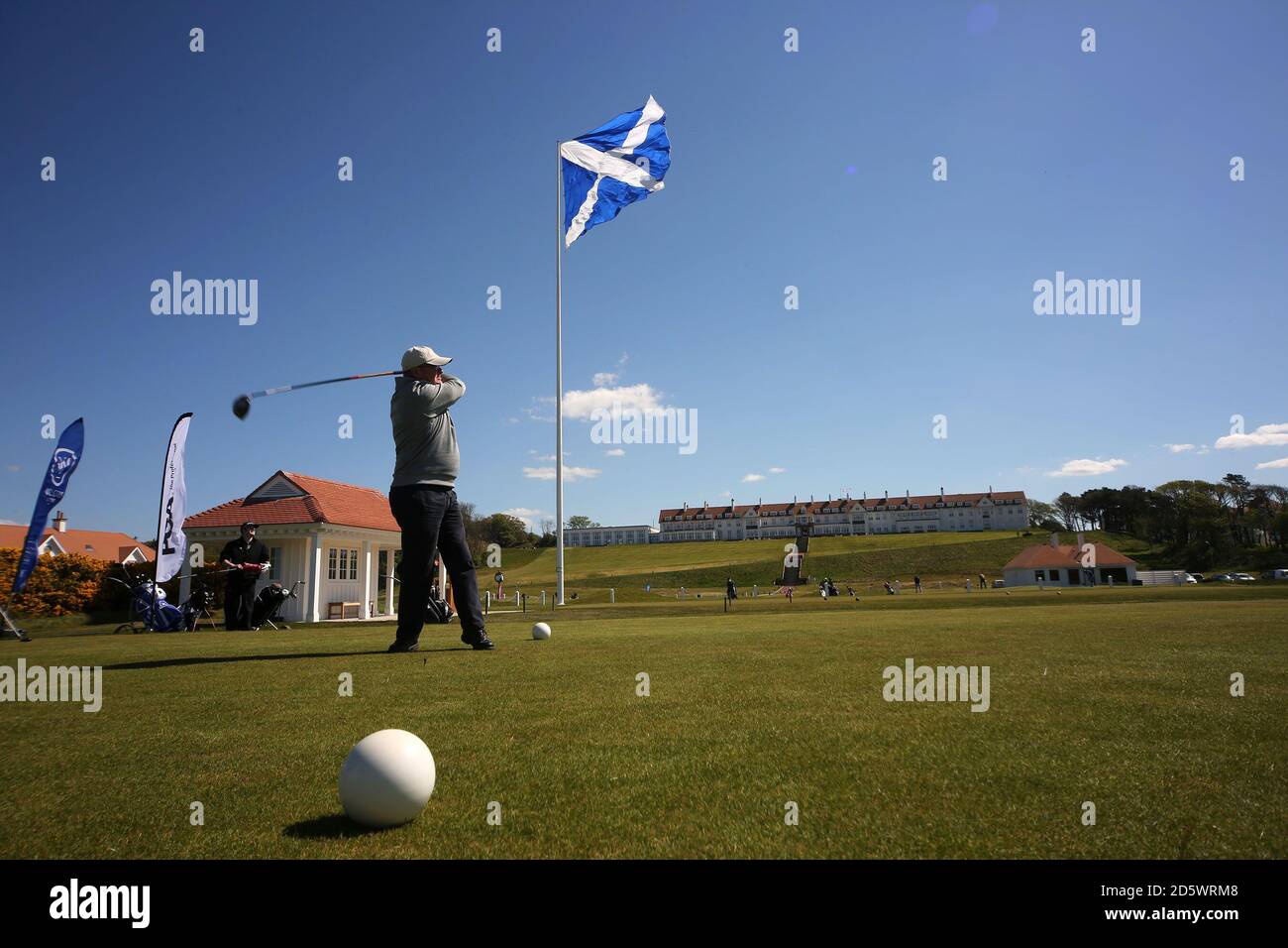 Trump Turnberry Golf Course First tee and starters Hut con Turnberry Hotel y la gran bandera de Satlire, golfista se aparta del tee Foto de stock
