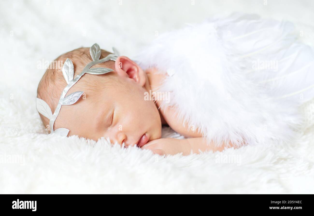 Bebé recién nacido en un traje de cupido con alas de ángel