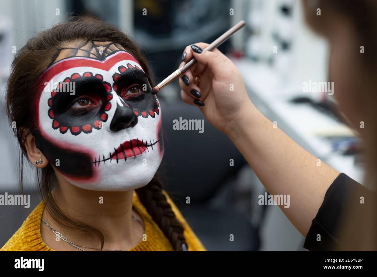 Maquillaje artista pinta la cara de una chica con pinturas para Halloween  Fotografía de stock - Alamy
