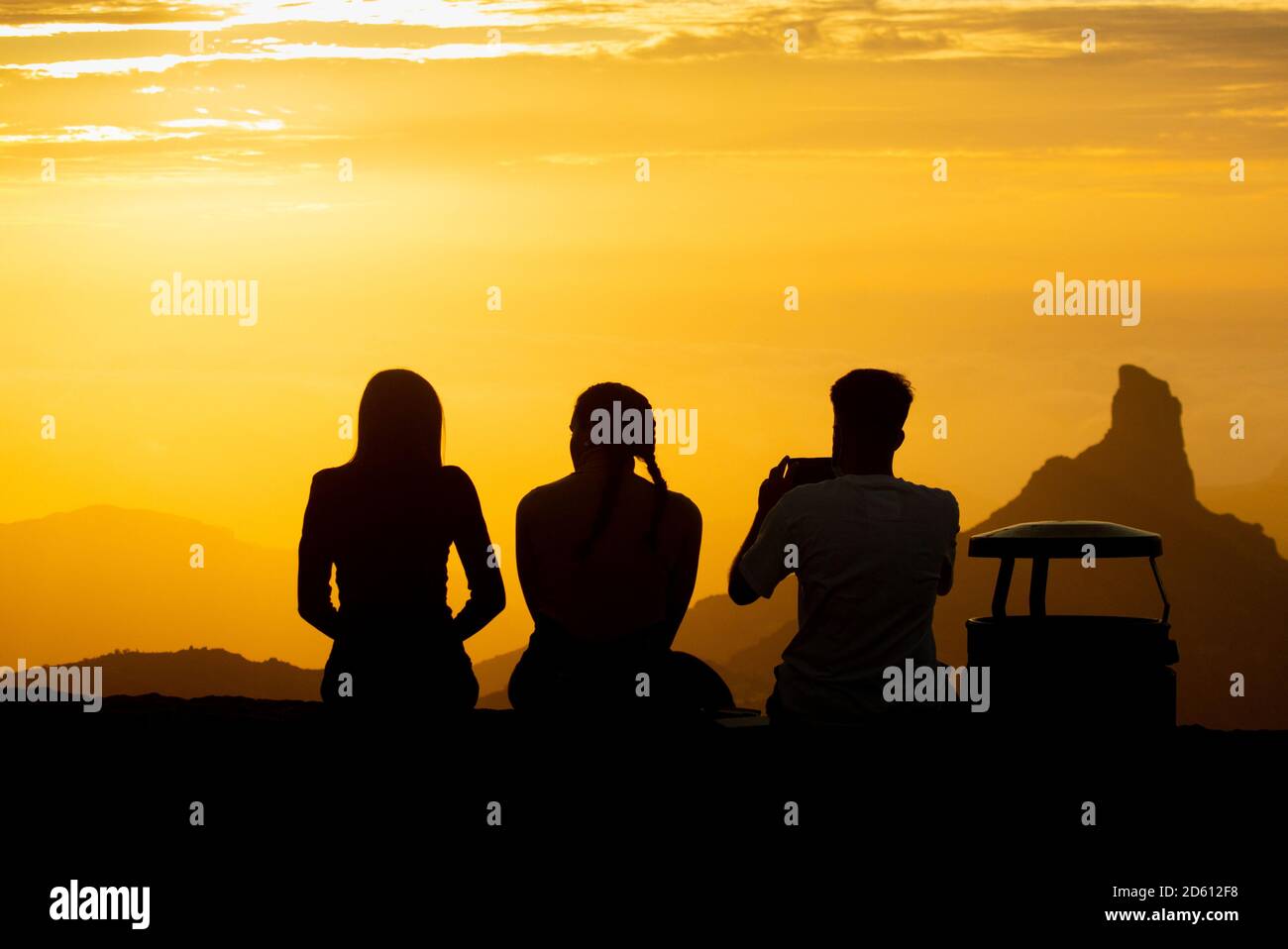 Gente viendo la puesta de sol en las montañas de Gran Canaria, Islas Canarias, España, Roque Bentaiga/Bentayga (derecha). Foto de stock