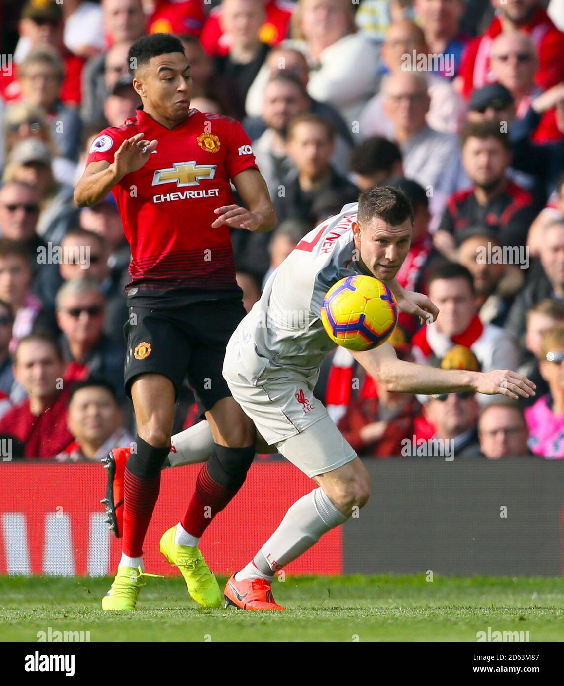 Jesse Lingard de Manchester United (izquierda) y la batalla de James Milner de Liverpool para la pelota Foto de stock