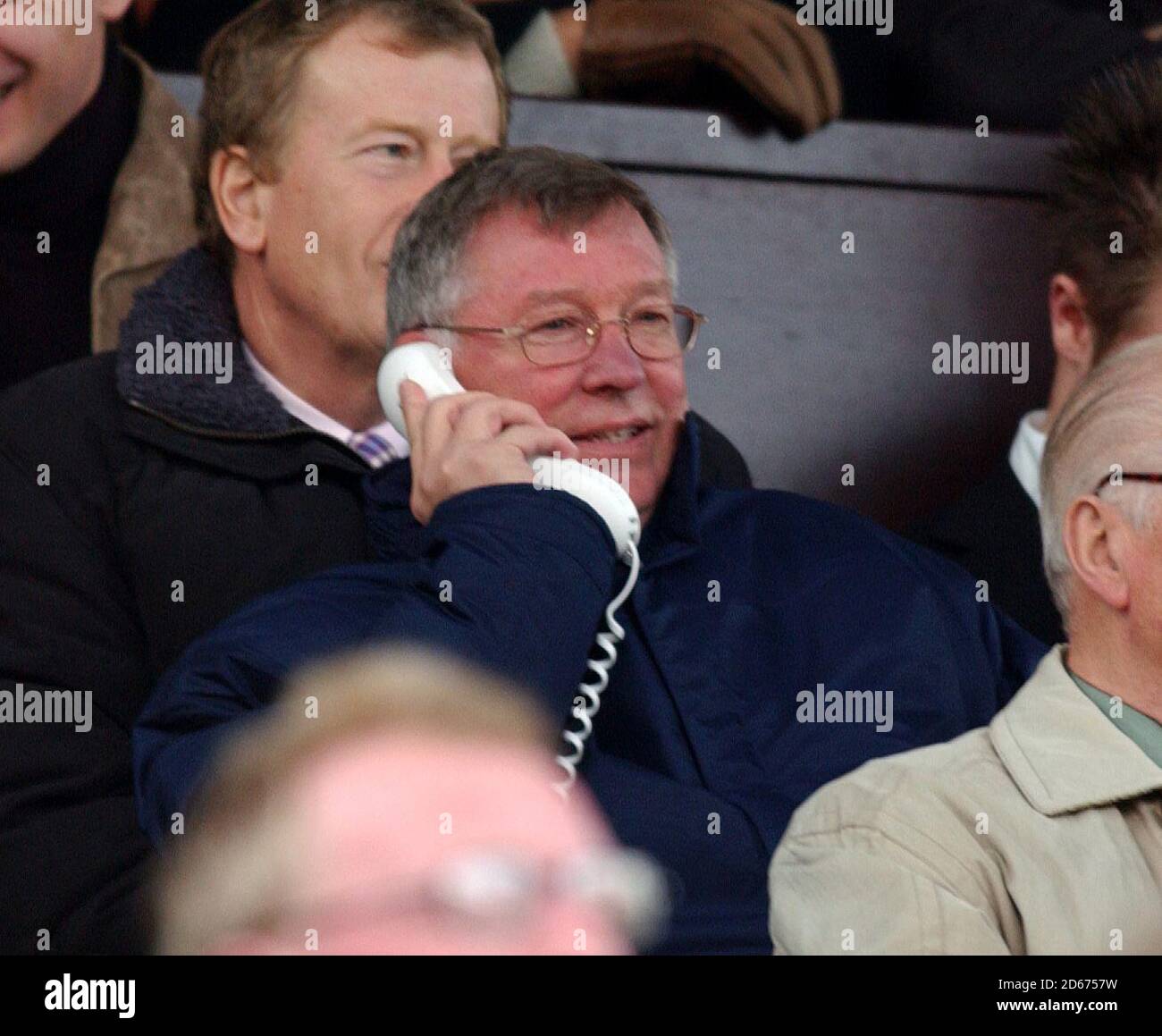 Alex Ferguson, gerente de Manchester United, inicia su prohibición de la línea de contacto, pero se mantiene en contacto con el banco por teléfono Foto de stock