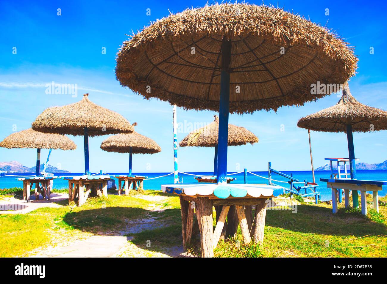 Sombrillas y mesas de playa exóticas. Terraza tropical de verano Foto de stock