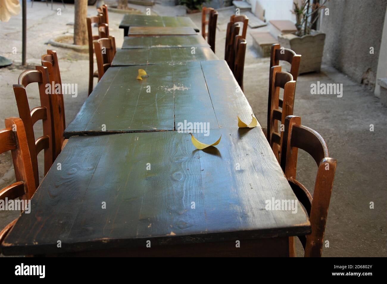 Sillas vacías y mesa larga de madera al aire libre restaurante en covid19  veces en Italia. No hay gente. Nadie. No hay contacto social Fotografía de  stock - Alamy