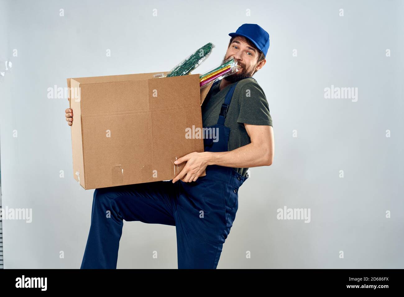 Hombre en el uniforme de trabajo con cajas en las manos entrega carga  estilo de vida Fotografía de stock - Alamy