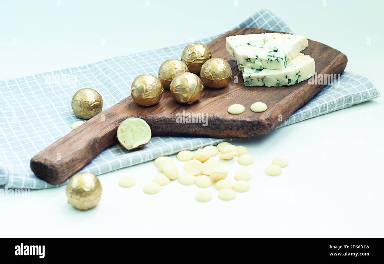 trufas de chocolate hechas de chocolate blanco y queso azul dor en una tabla de madera Foto de stock