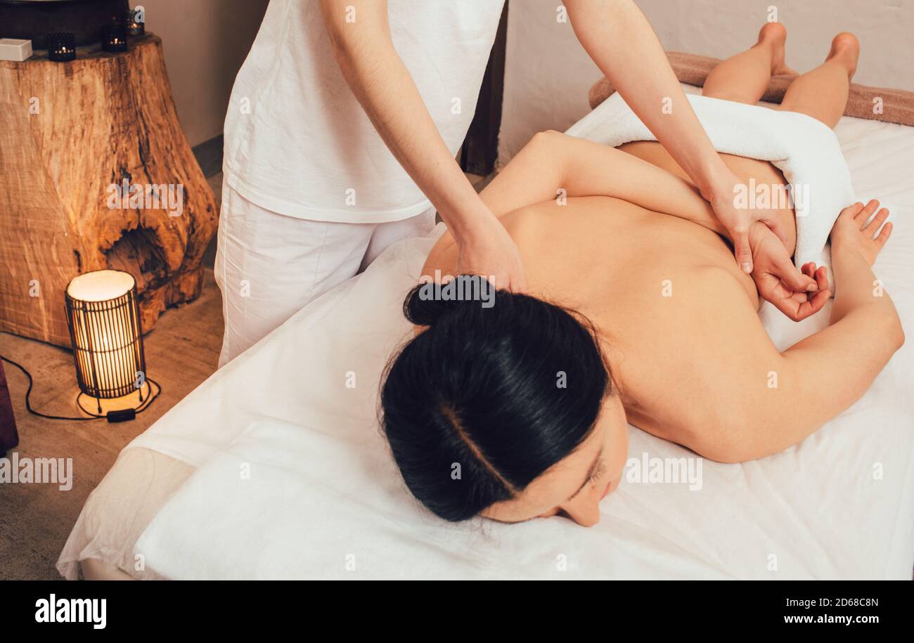 Masaje de bienestar en el spa. Mujer recibiendo masaje de espalda y masaje corporal anti-estrés Foto de stock