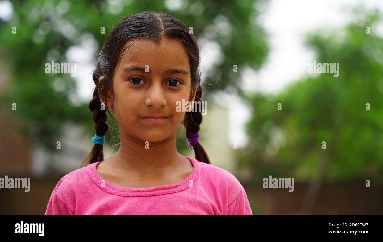 Sikar, Rajasthan, India - Ago 2020: Feliz y sonriente niña de pueblo indio de pie. Retrato de cara sonriente de un niño pequeño o una niña de la zona rural Foto de stock