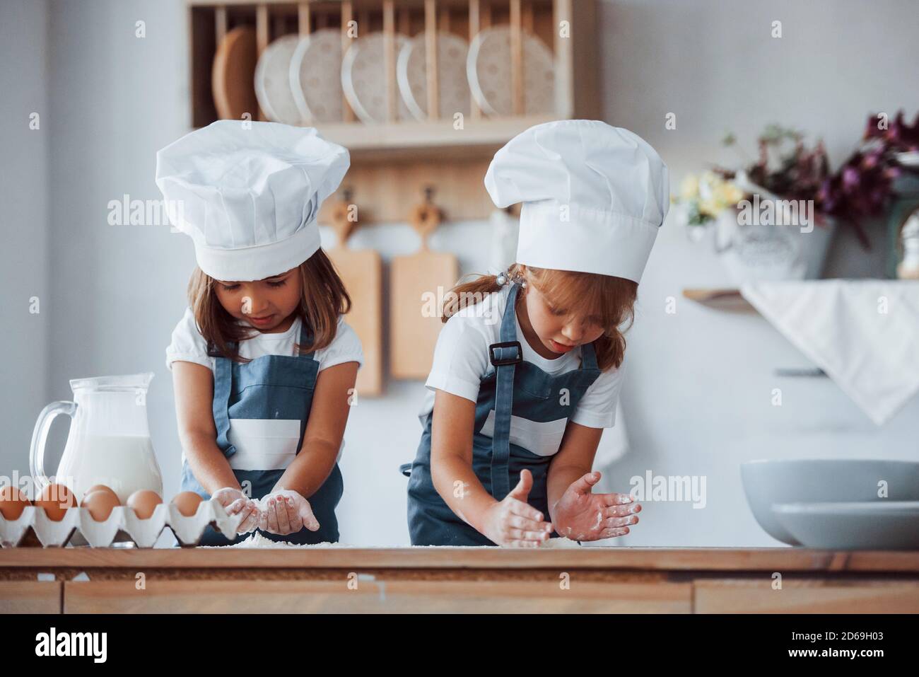 Los niños de la familia en el uniforme blanco del chef preparando la comida en el cocina de stock - Alamy