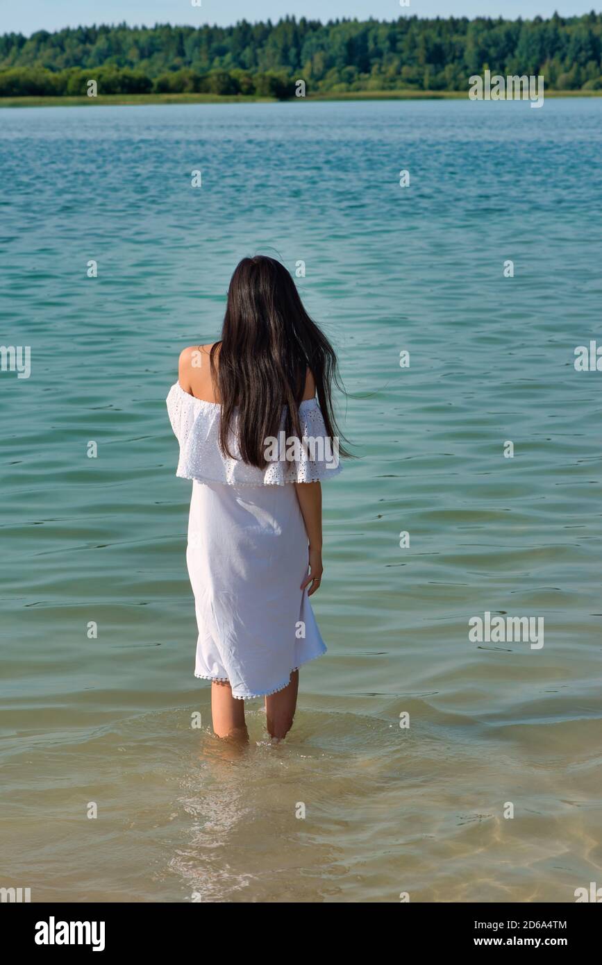 Espalda de mujer en el agua en la hermosa playa de colores Fotografía de  stock - Alamy
