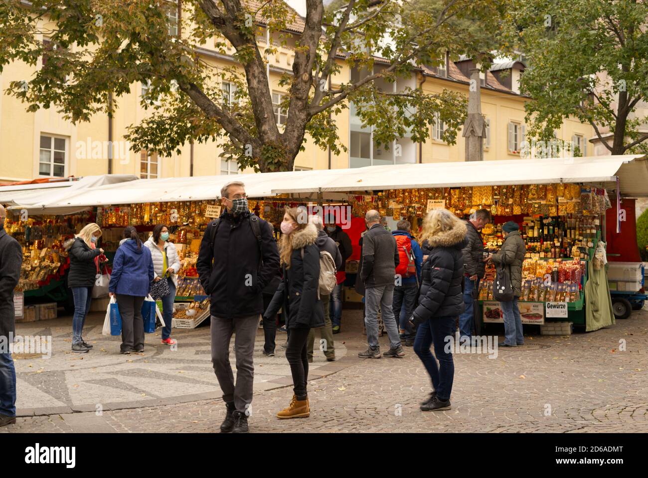 Street vendor se detiene en Merano, BZ, Italia en otoño 15 de octubre de 2020 imagen con los turistas usando una máscara de protección facial. Foto de stock