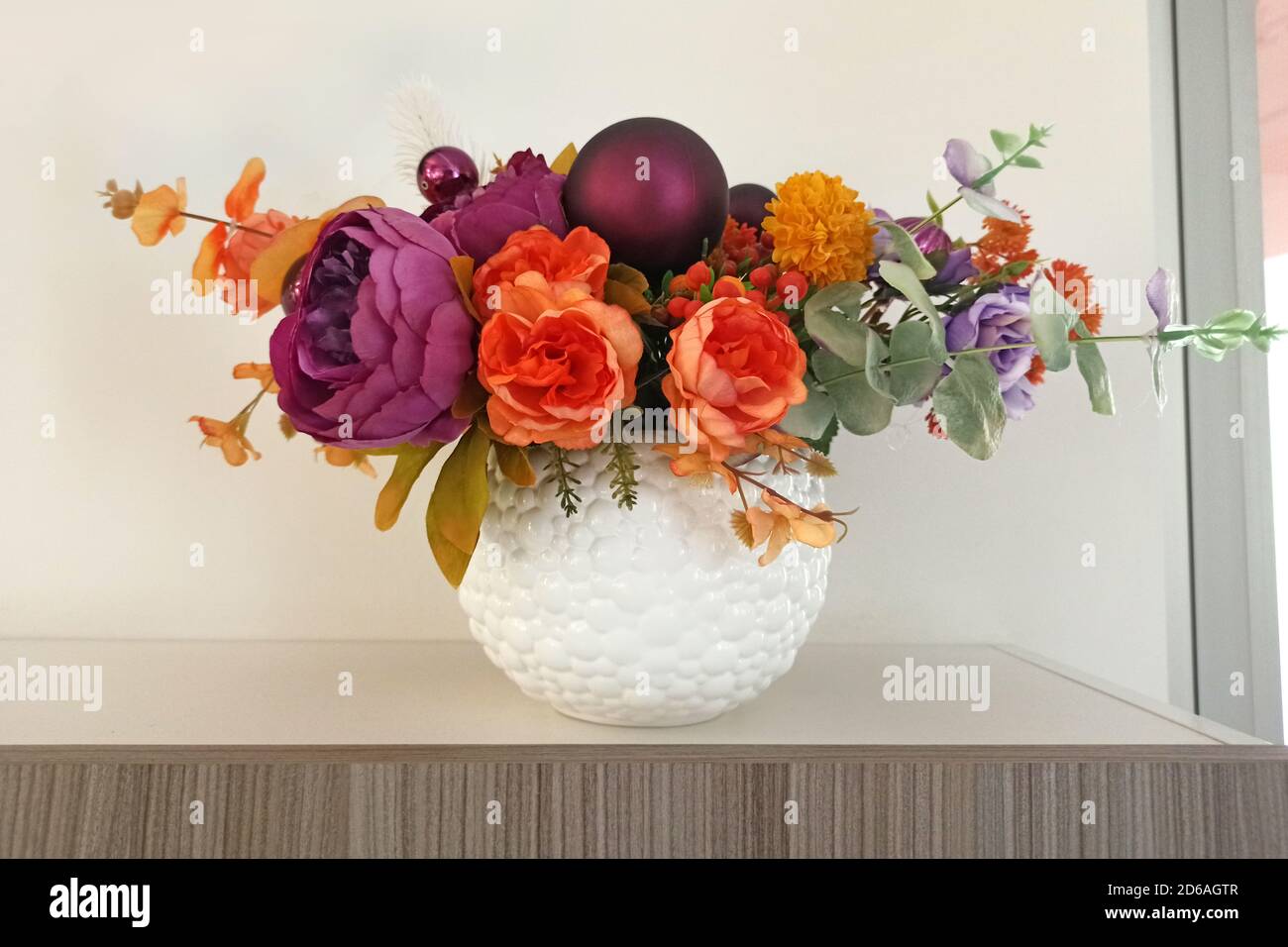 Flores artificiales en un jarrón blanco en un estante de la habitación.  Flores de tela como elemento de decoración interior. Peonías artificiales,  un ramo de flores en Fotografía de stock - Alamy