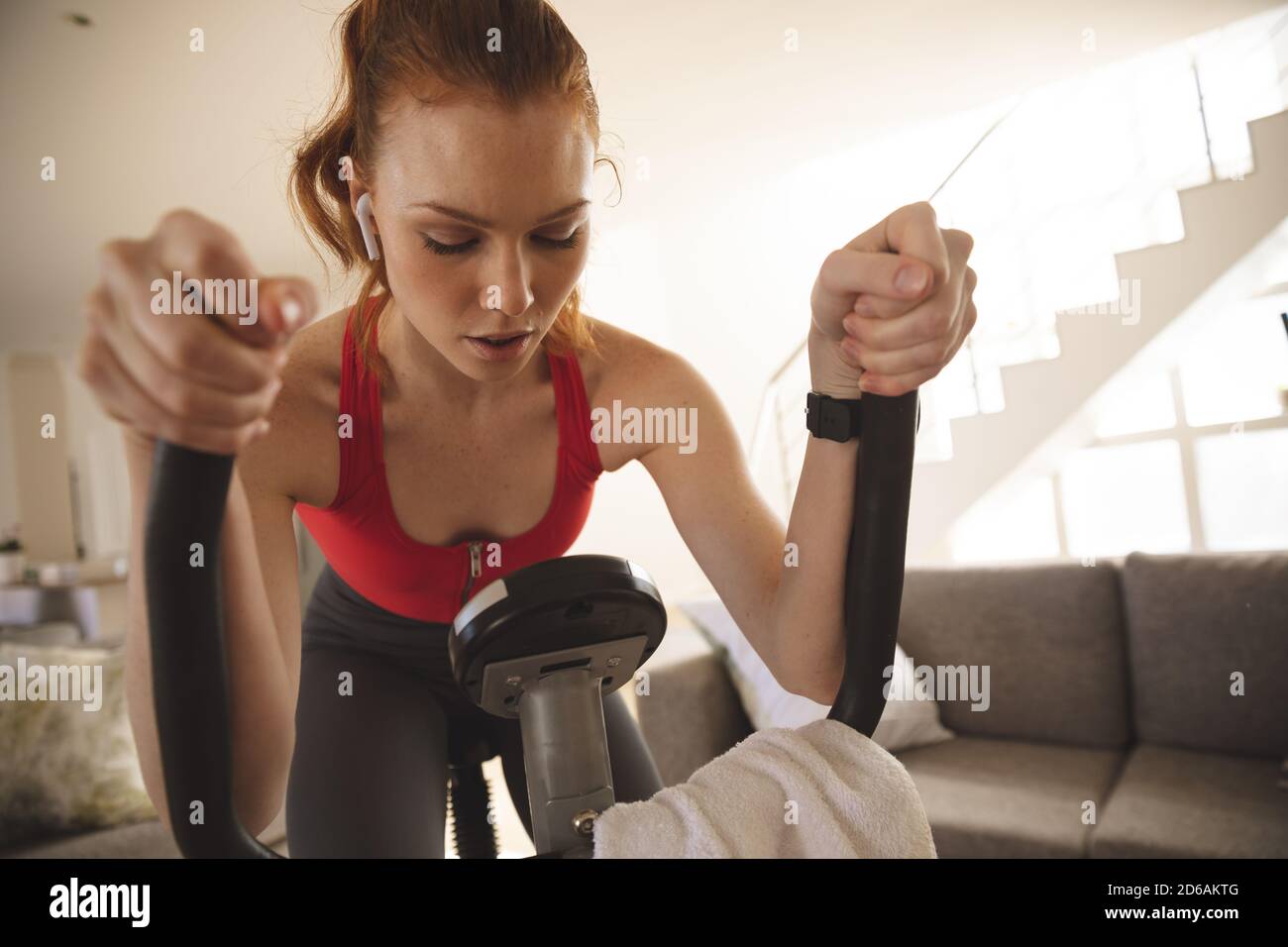 Mujer haciendo ejercicio en bicicleta estática en casa Foto de stock
