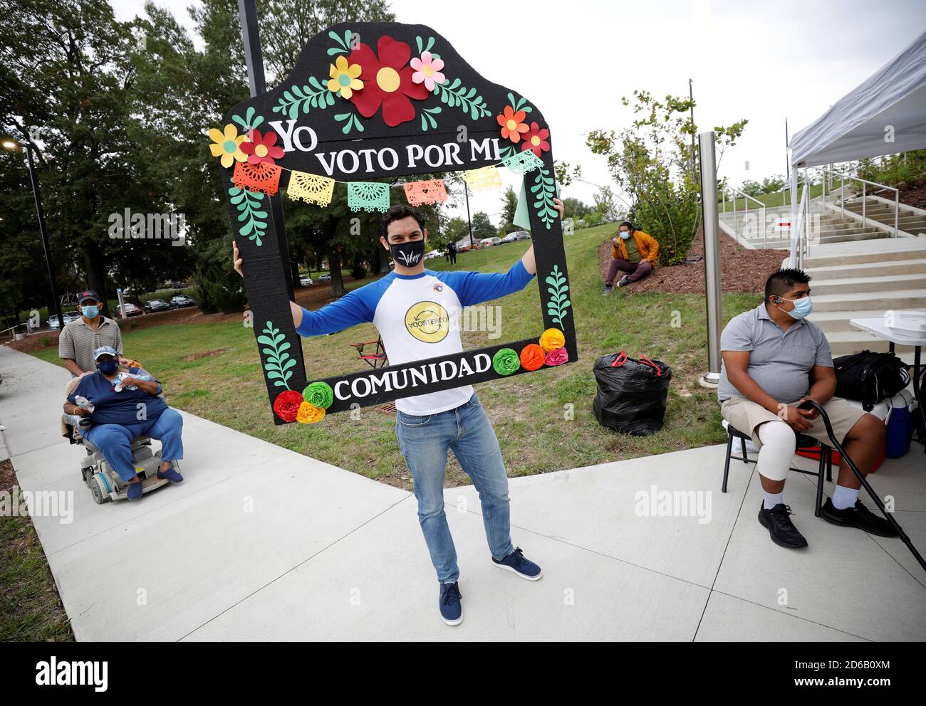 Un hombre que acaba de emitir su boleta sostiene un cartel que dice \