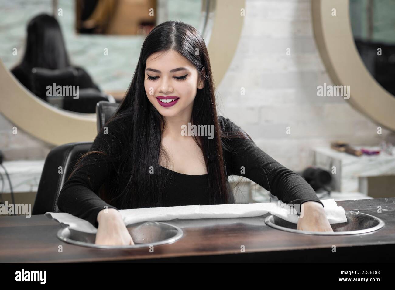 Niña India bastante joven sentada en un salón de manicura, concepto de salón de belleza, concepto de belleza y cuidado de la salud. Foto de stock