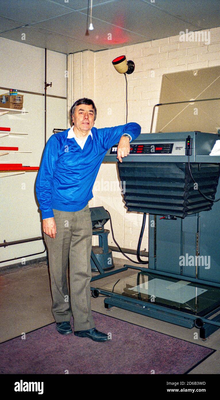 Hombre de pie junto a una cámara de reprografía Foto de stock