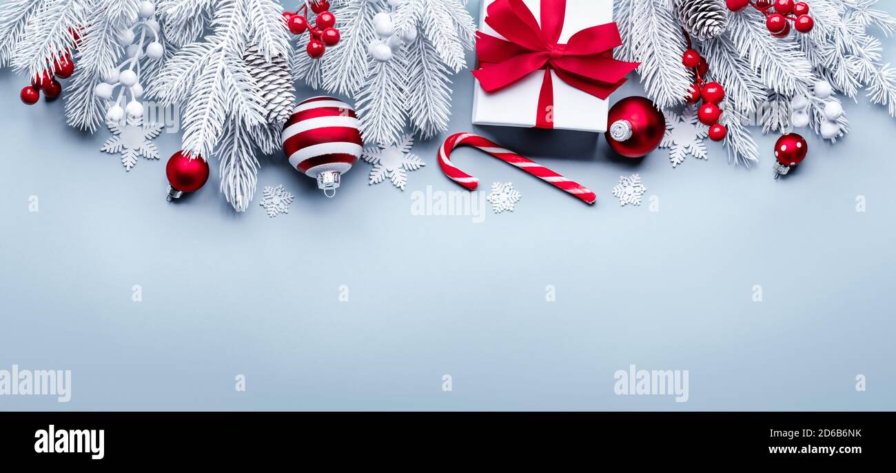 Caja de regalo, bolas rojas y rama de abeto sobre fondo azul claro Foto de stock
