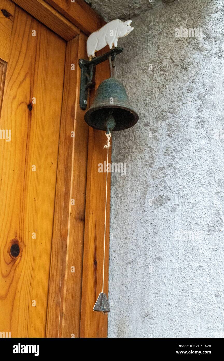 campana vintage colgando en una puerta para sonar Fotografía de stock -  Alamy