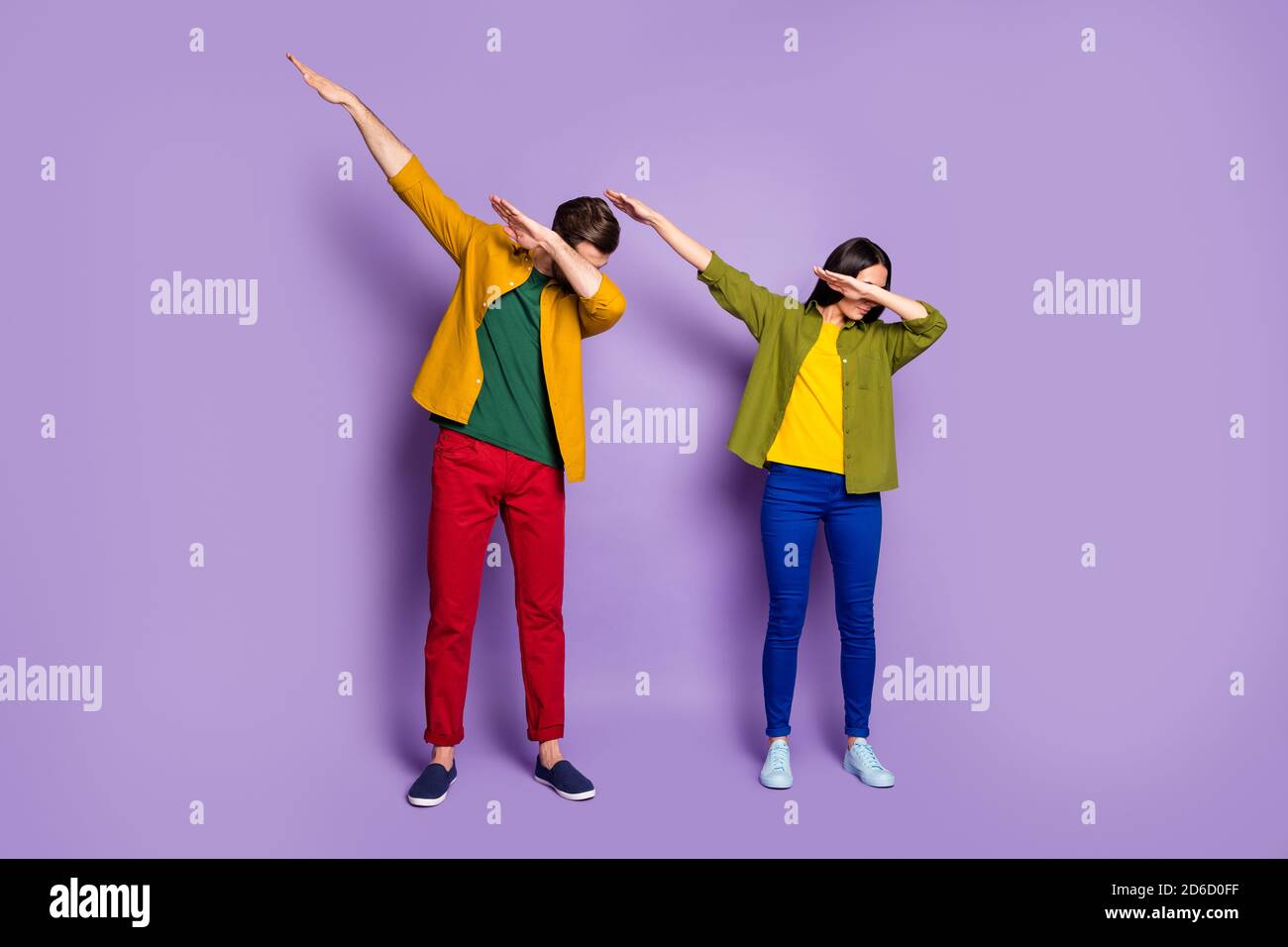 Cuerpo entero foto dama estudiante dos personas pareja los jóvenes modernos y extraños se mueven con el paso de la puñalada ropa verde informal amarillas pantalones zapatos Fotografía de stock -