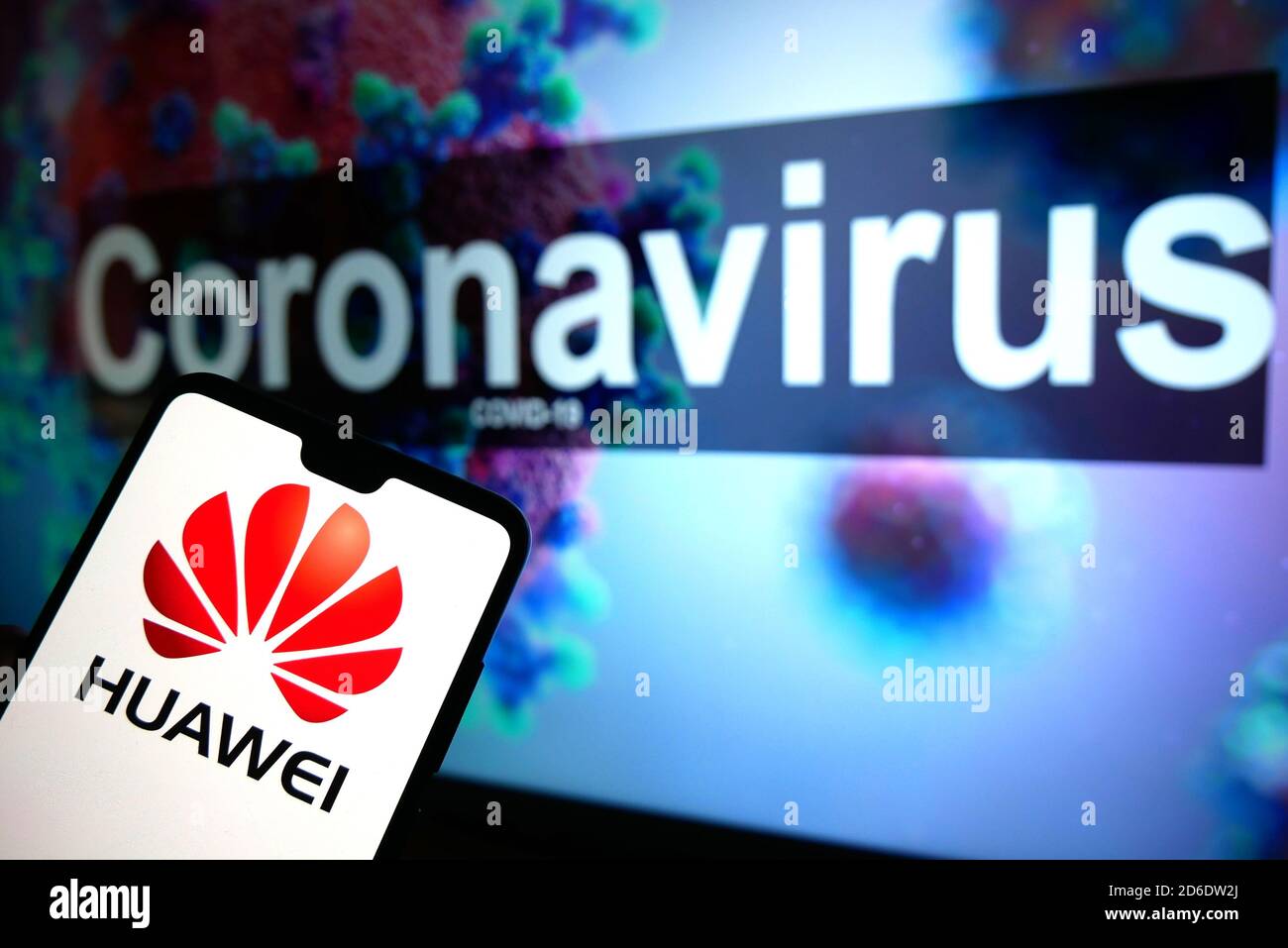 El logotipo de Huawei visto en un teléfono móvil con un modelo ilustrativo del Coronavirus mostrado en un monitor en el fondo. Foto de stock