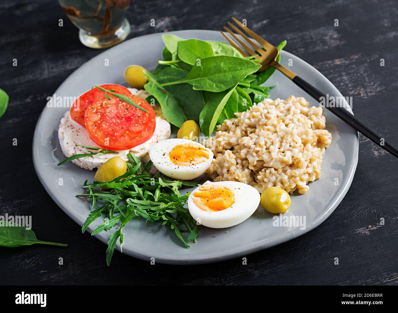 Gachas de avena de desayuno con huevo cocido, sándwich de tomate, rúcula y  espinacas. Alimentos saludables Fotografía de stock - Alamy