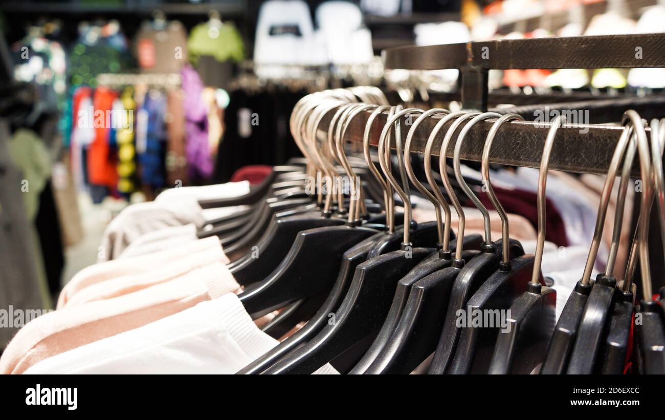 De cerca, la ropa moderna y moderna para mujer cuelga de perchas de plástico negro en tienda de ropa. Compras línea para el coágulo casual Fotografía de stock - Alamy