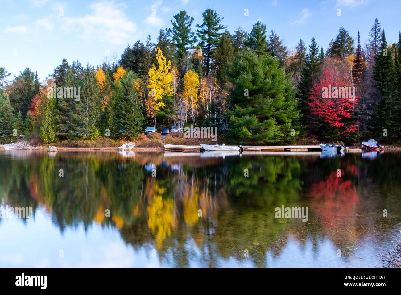 Hermoso paisaje canadiense: Árbol verde, amarillo y rojo que se refleja en un lago Foto de stock